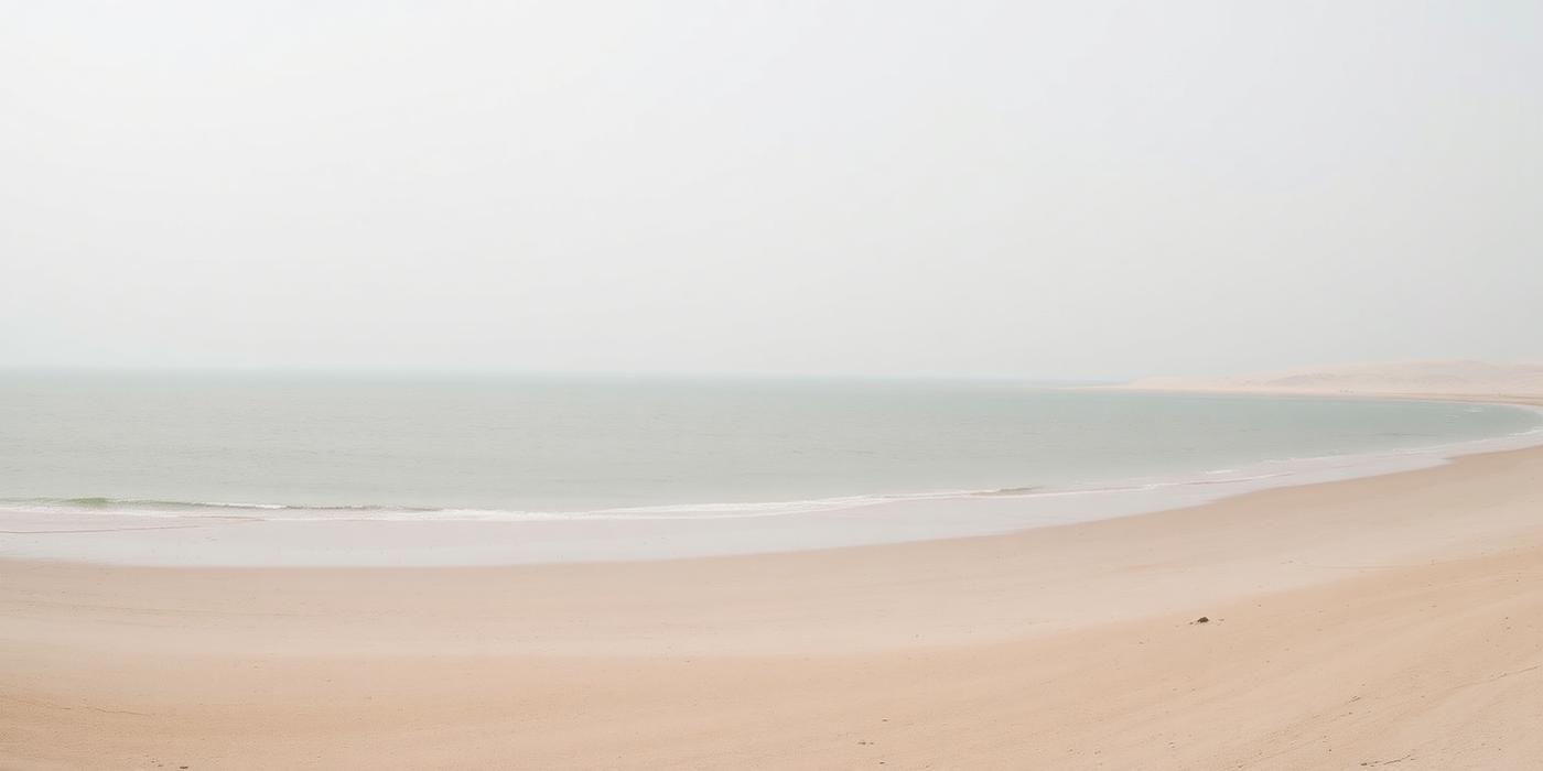 Quiet shoreline with pale sand and shallow water